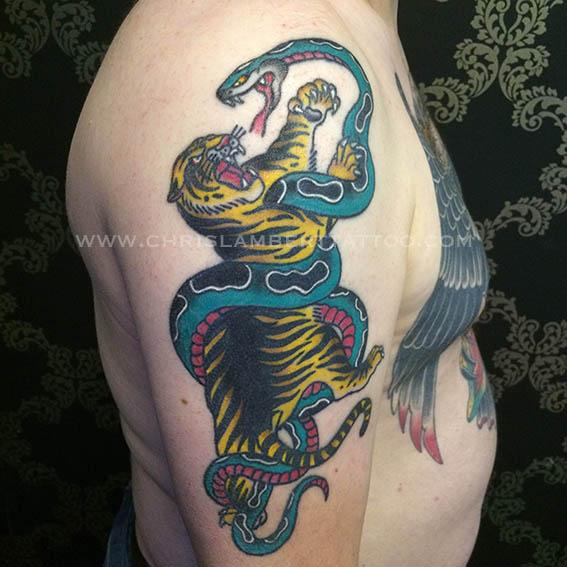 snake and tiger tattoo on upper arm